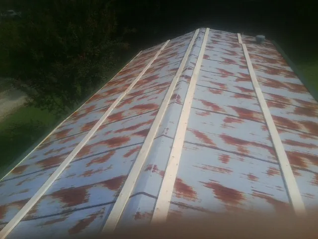 Rusted metal roof panels with new wood purlins before replacement — Storm Damage Roof Repair in Morehead City by Roofing Brothers