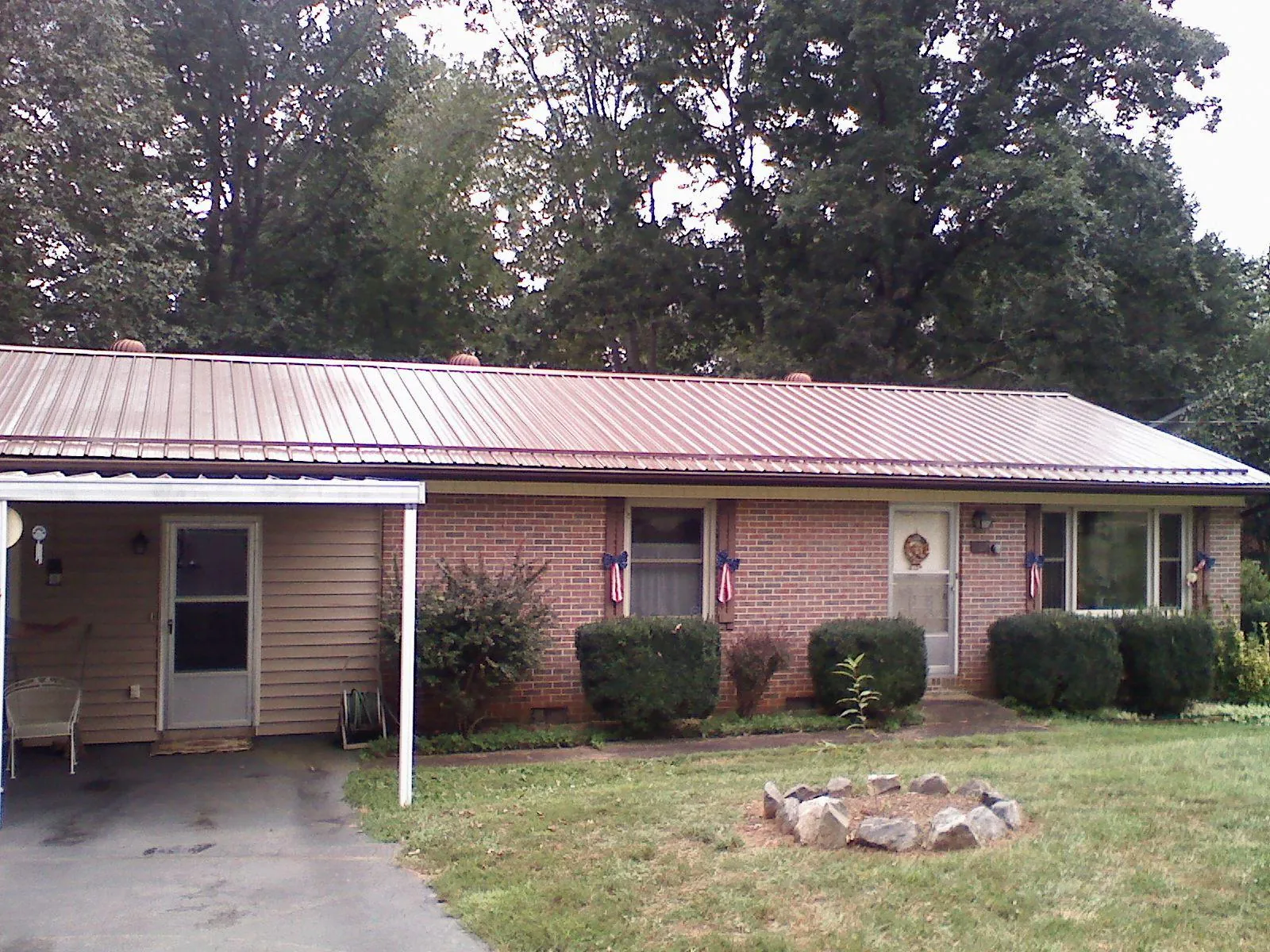 Bronze metal roof and carport on a brick ranch home — Roof Repair work by our crew in Morehead City
