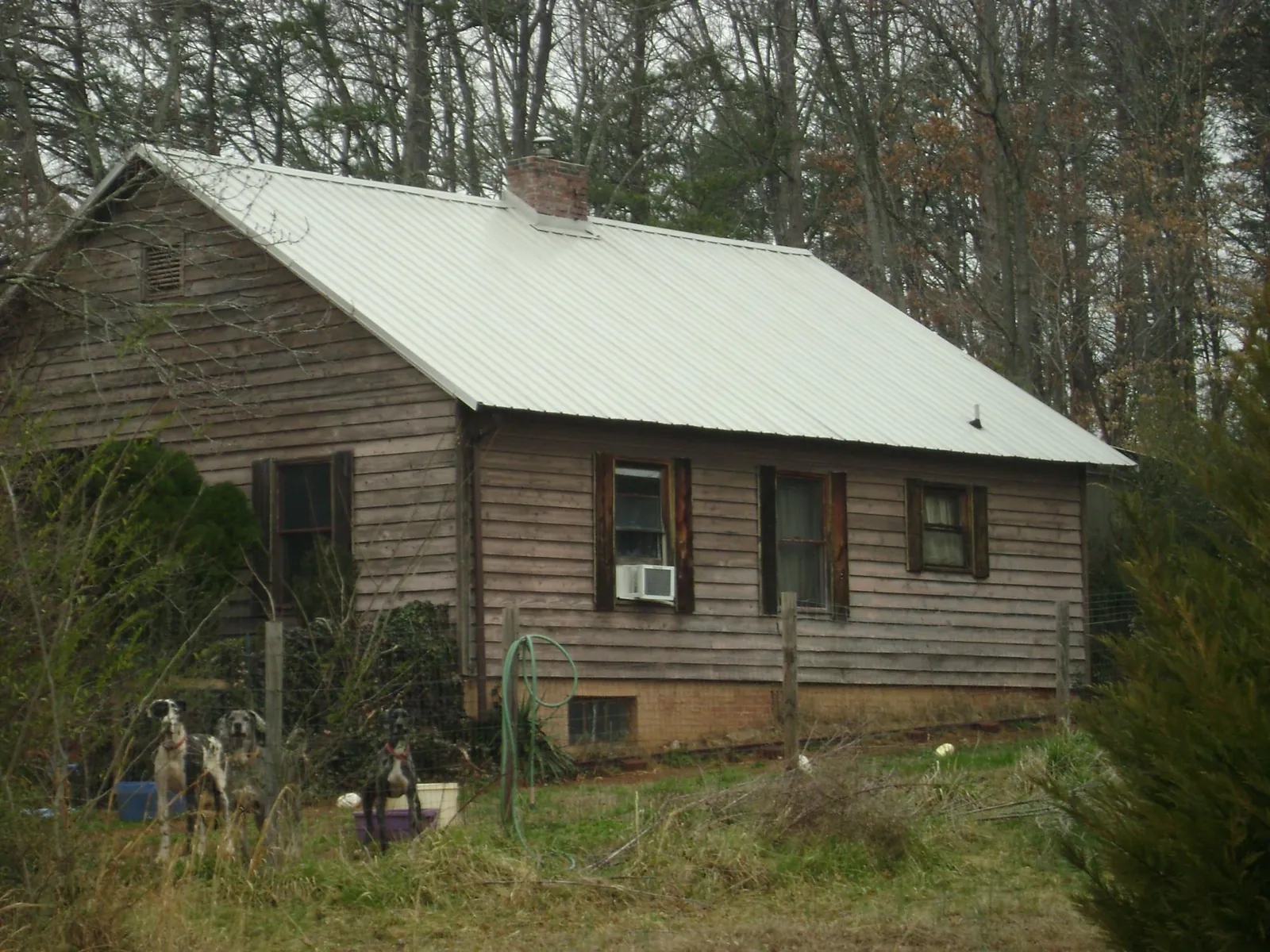White metal roof on an old wood sided farmhouse, from a Metal Roof Installation job in Morehead City
